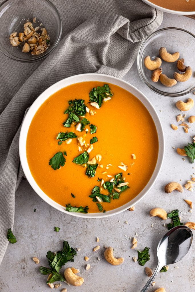 overhead shot of a bowl of Cashew Carrot Ginger Soup in a white bowl