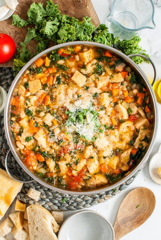a pot of Simple Ribollita Italian Bean Soup garnished with freshly grated Parmesan cheese