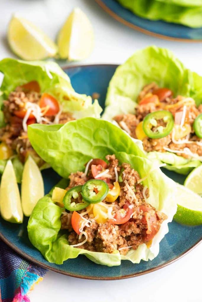 Turkey Taco Lettuce Wraps on a round blue plate with lime wedges