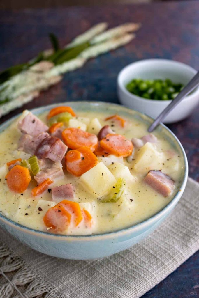 a white bowl with Crock Pot Ham and Potato Soup