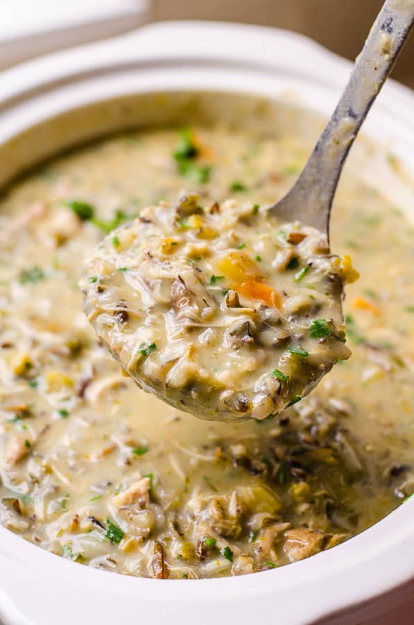 Healthy Chicken Wild Rice Soup in a ladle over the pot of soup