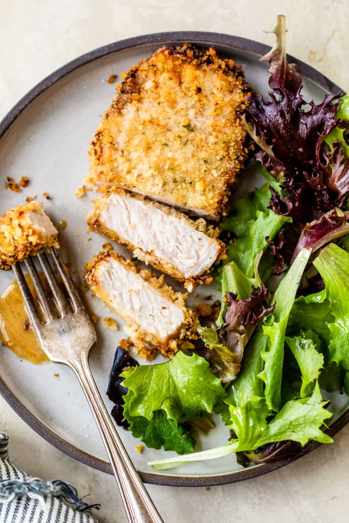 Honey Mustard Air Fryer Pork Chops ona plate with salad greens - one of the recipes for this week's healthy weekly meal plan