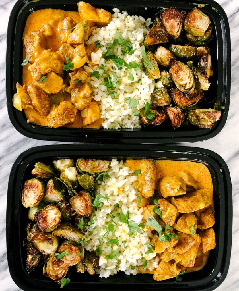 Whole30 Butter Chicken meal prepped in black containers with cauliflower rice and Brussels sprouts - one of the recipes for this week's healthy weekly meal plan