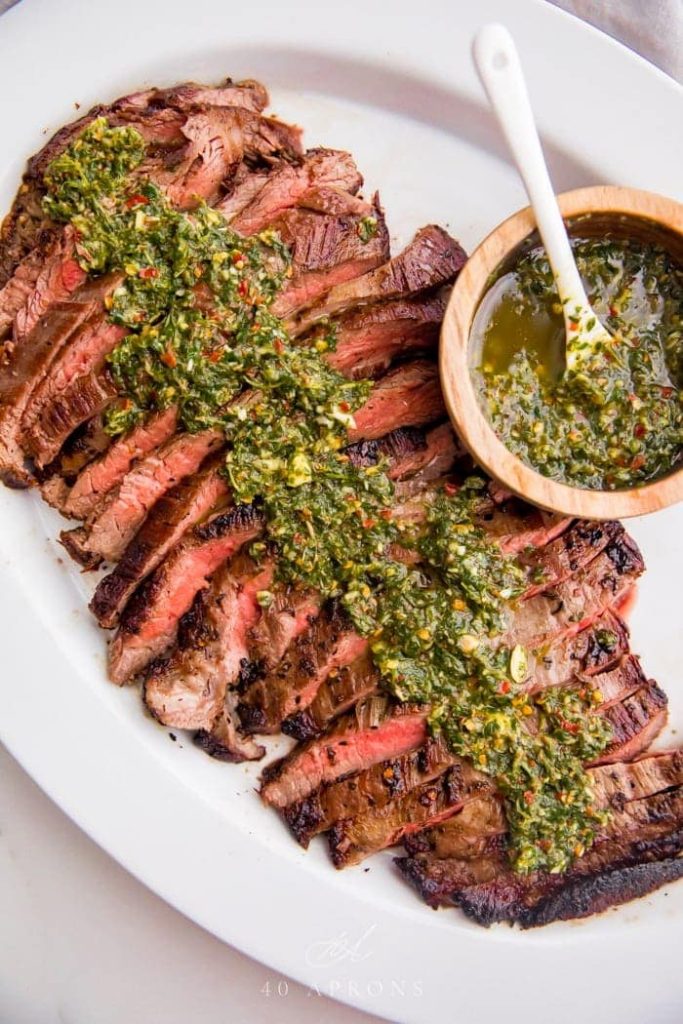 Sliced Chimichurri Steak on a white platter - one of the recipes for this week's healthy weekly meal plan