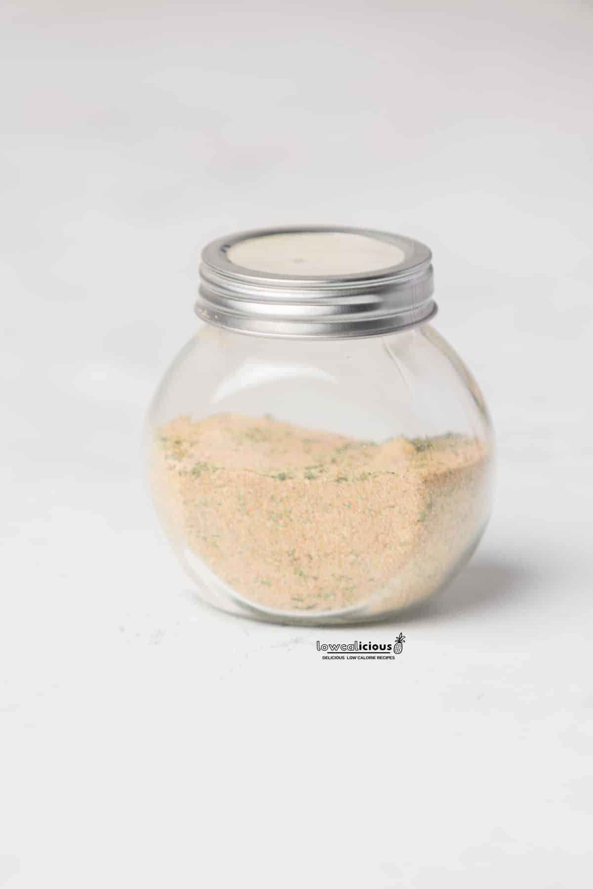 a homemade chicken seasoning recipe (chicken rub) stored in a clear glass jar with a silver screw-on top