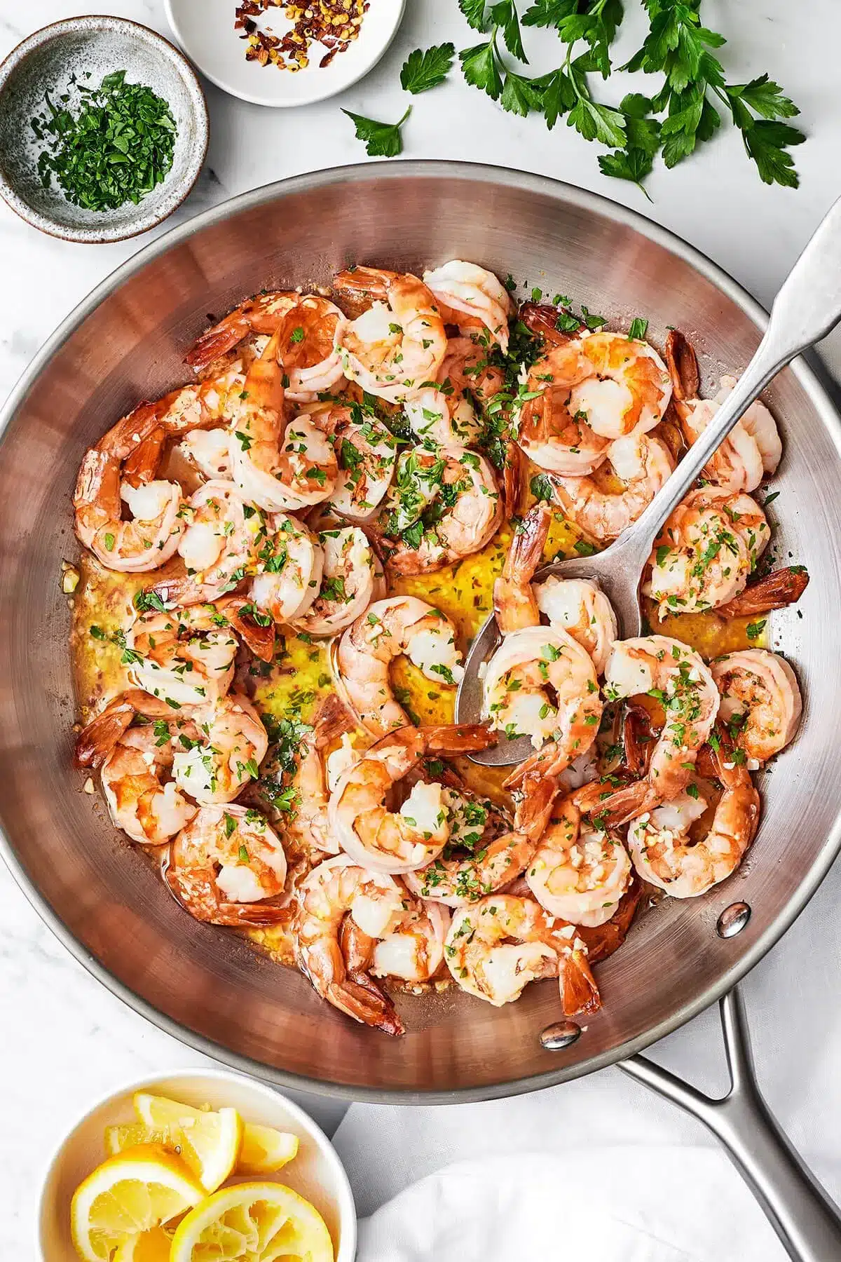 overhead shot of Shrimp Scampi cooked in a silver pan garnished with fresh parsley - one of the recipes for this week's healthy weekly meal plan