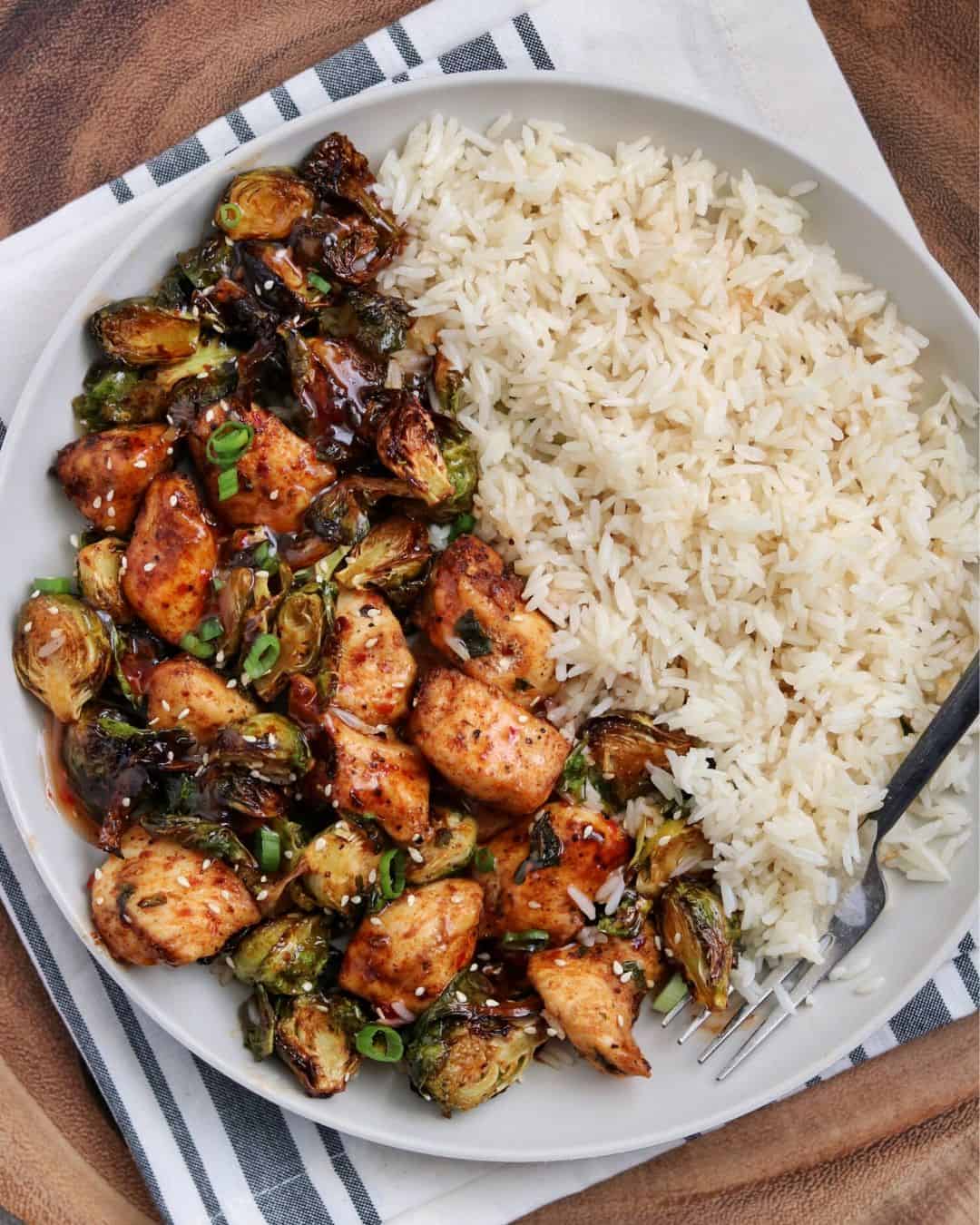 overhead shot of cooked Air Fryer Sweet Chili Chicken and Brussels Sprouts on a plate with rice - one of the recipes from this week's healthy weekly meal plan