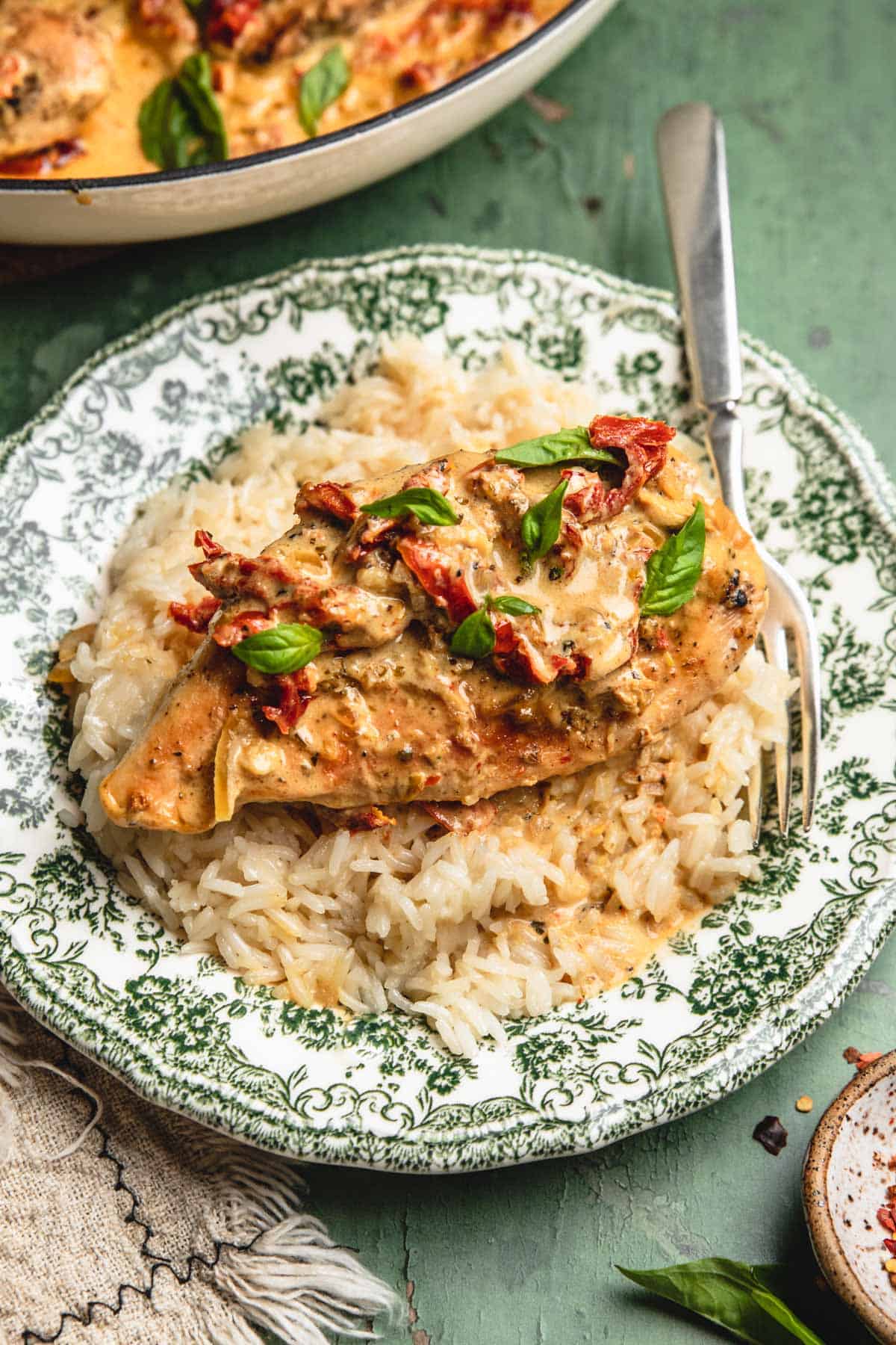 Healthy Marry Me Chicken plated over rice on a green and white plate - one of the recipes for this week's healthy weekly meal plan