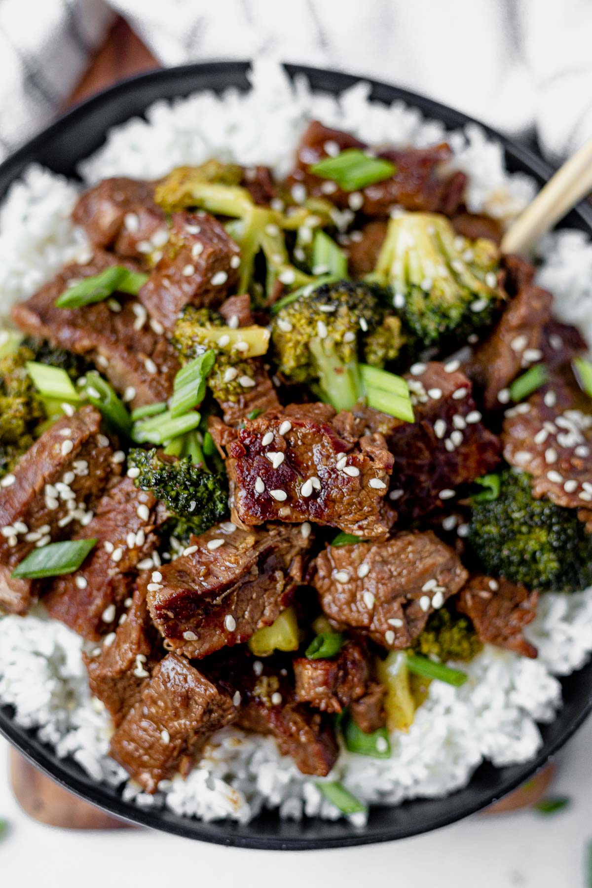 overhead shot of cooked Instant Pot Mongolian Beef served on top of white rice topped with cooked broccoli and sesame seeds - one of the recipes for this week's healthy weekly meal plan