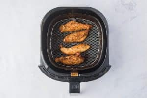 overhead shot of cooked air fryer chicken tenders in an air fryer basket