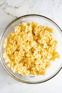 cooked bow tie pasta in a large glass bowl to make Healthy Southwest Pasta Salad recipe (Vegan)