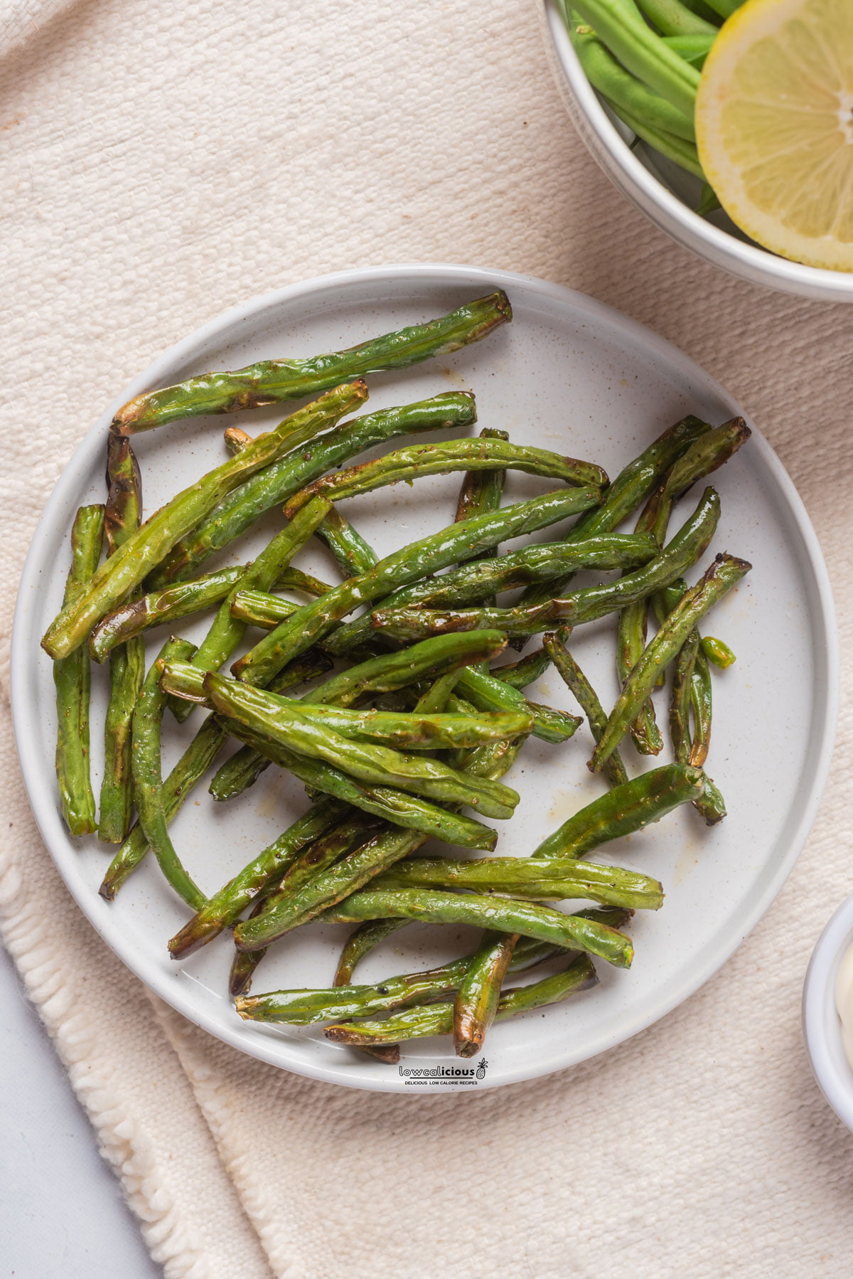 cooked Air Fryer Green Beans on a round white plate ready to serve