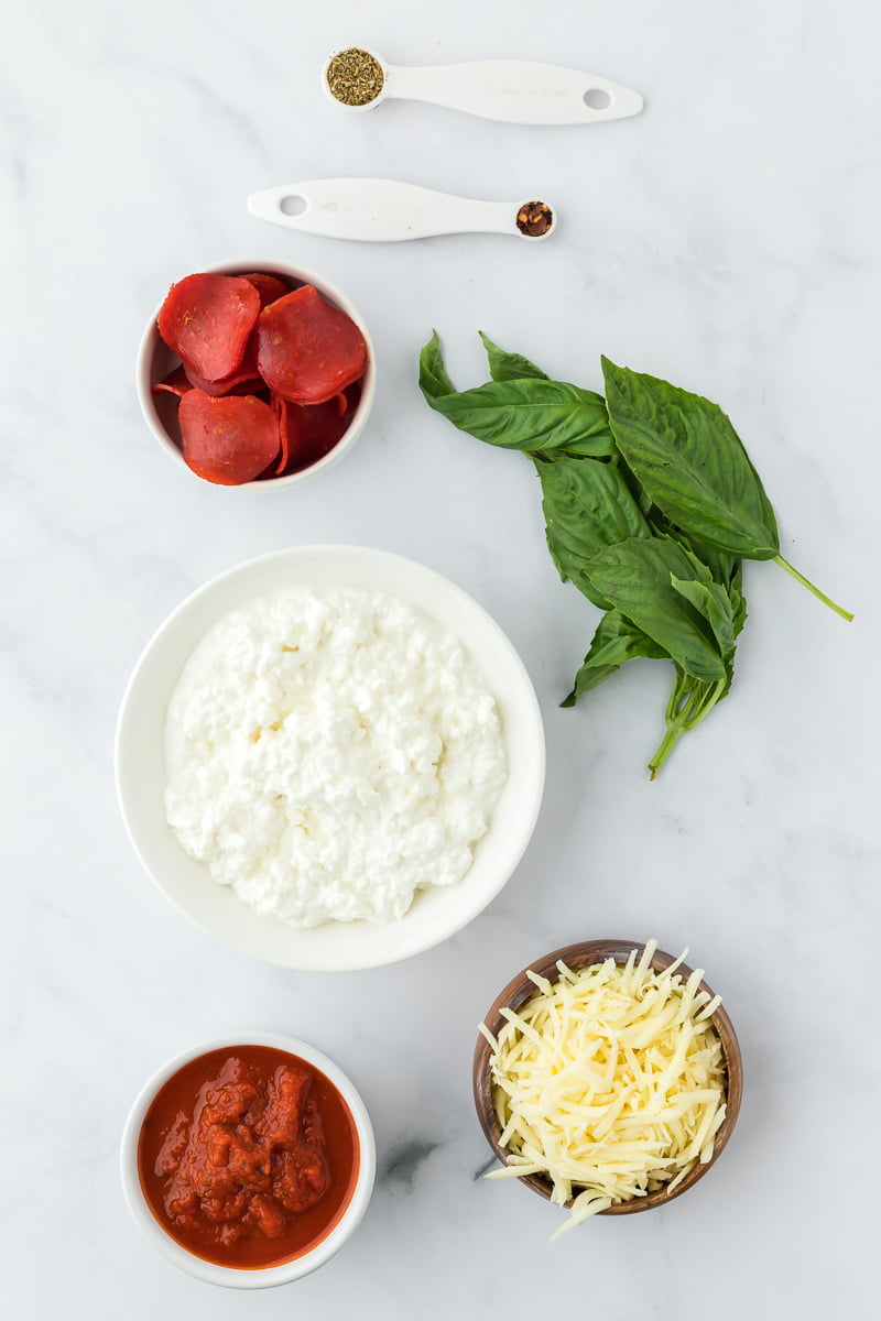ingredients in individual bowls and measuring cups/spoons to make cottage cheese pizza bowls