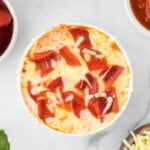 overhead shot of a cooked Cottage Cheese Pizza Bowl (Viral TikTok Recipe) in a white ramekin topped with melted cheese and chopped turkey pepperoni