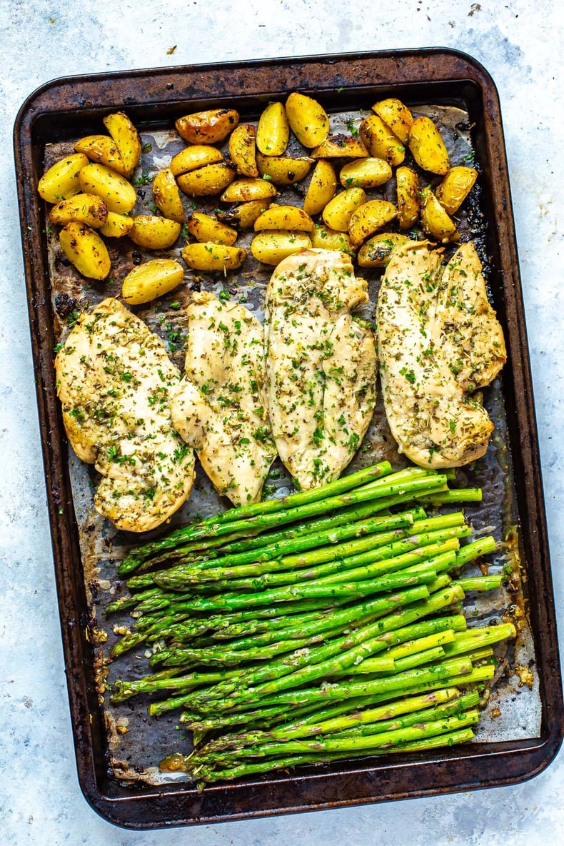 cooked Chicken and Asparagus on a sheet pan with potatoes