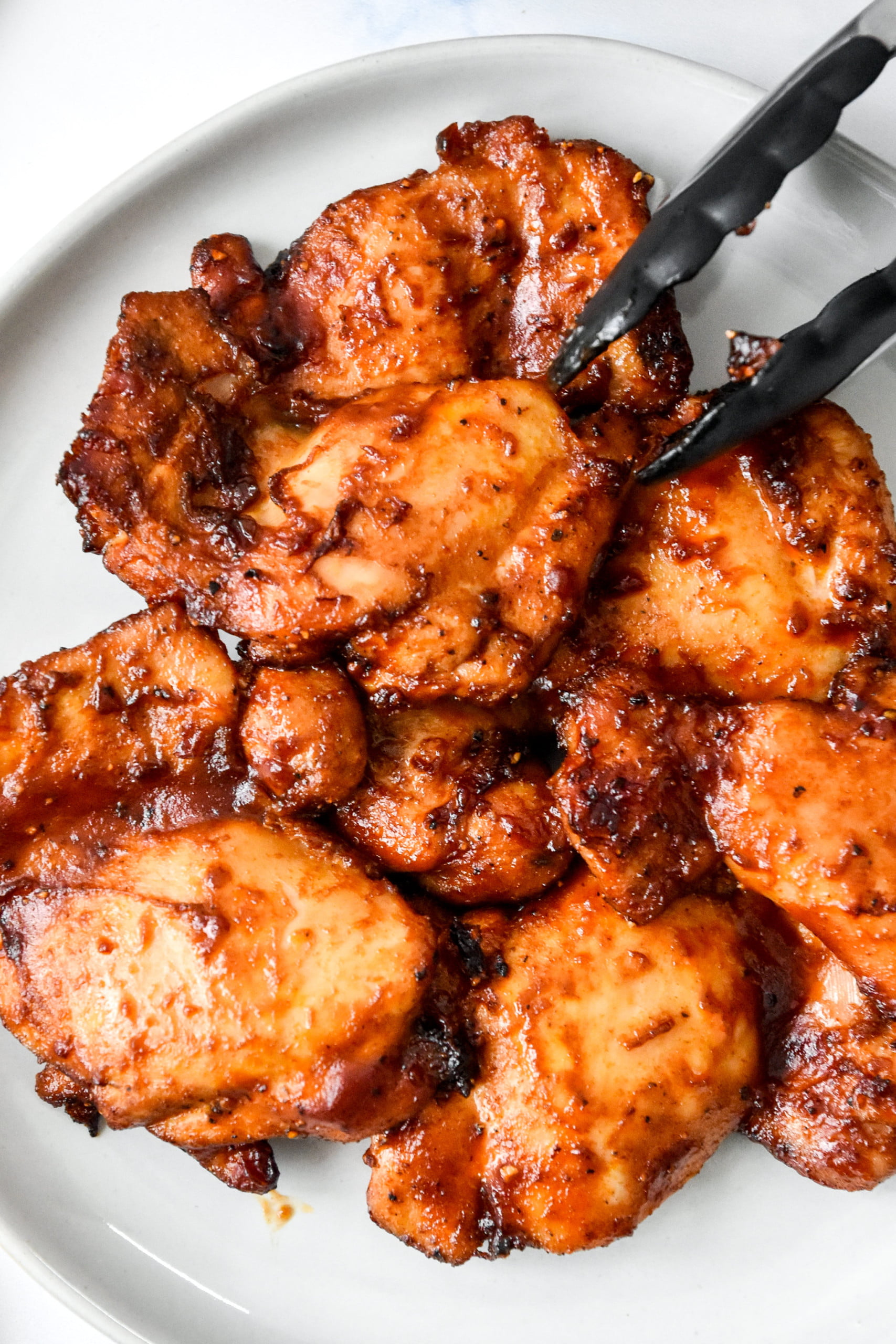 Air Fryer Boneless BBQ Chicken Thighs on a round white plate - one of the recipes for this week's healthy weekly meal plan