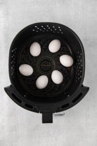 6 white large eggs placed in an Air Fryer Basket to make air fryer hard boiled eggs