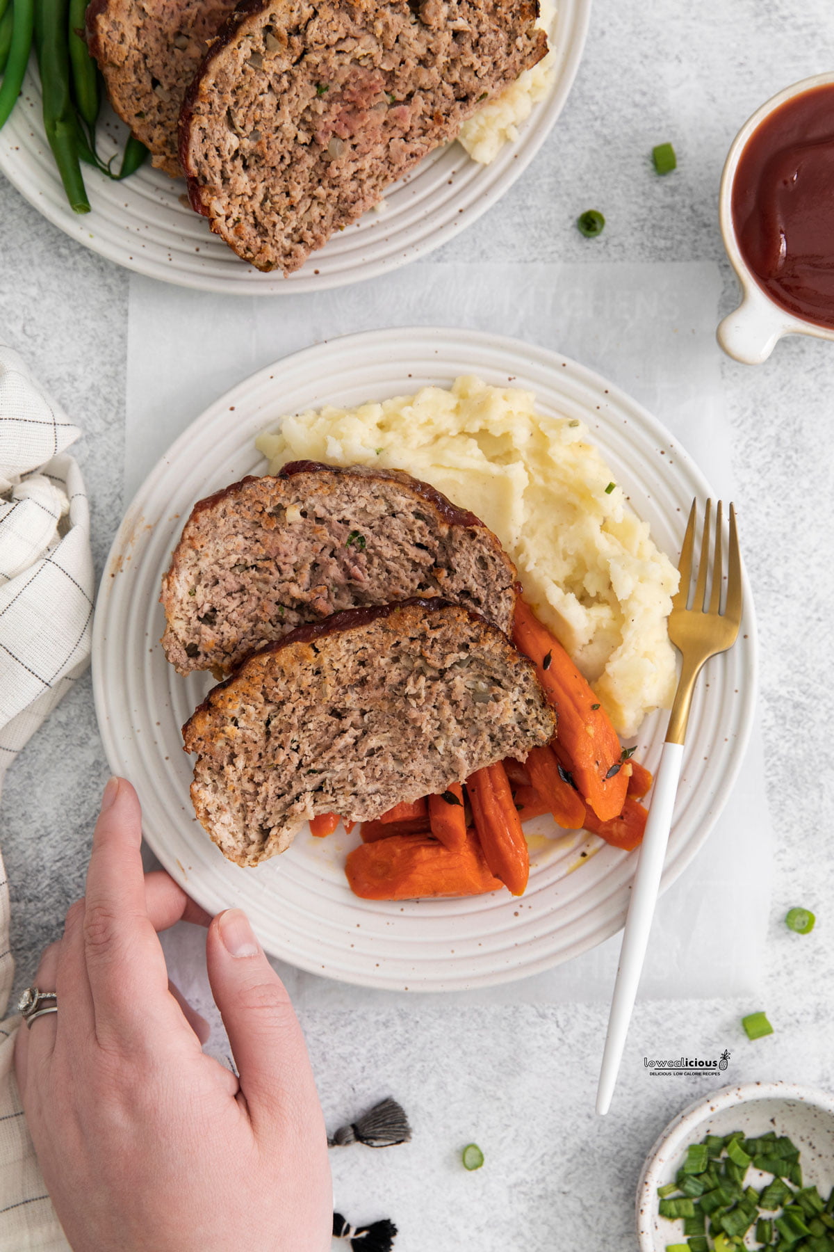 cooked healthy Air Fryer Meatloaf plated on a round white plate with mashed potatoes and roasted carrots. 